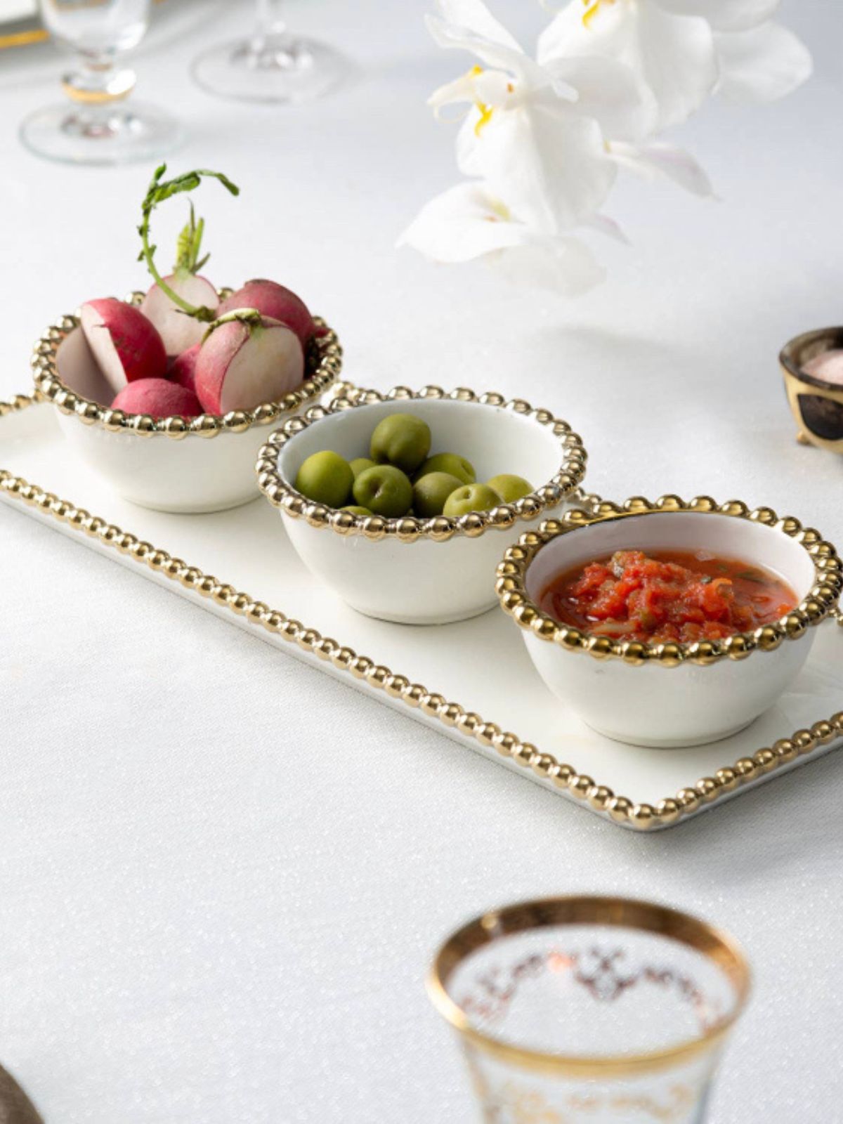 Augment your table decor with this beautiful 3-bowl white and gold beaded dish. Featuring three small-sized bowls, it's perfectly proportioned to serve creamy dips or sauces during dinner parties.