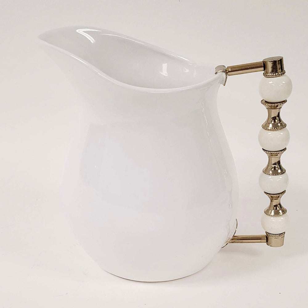 The Perline White Pitcher features a beaded handle that is oh so stunning. Use it to serve your favorite beverage or to style a beautiful floral arrangement.