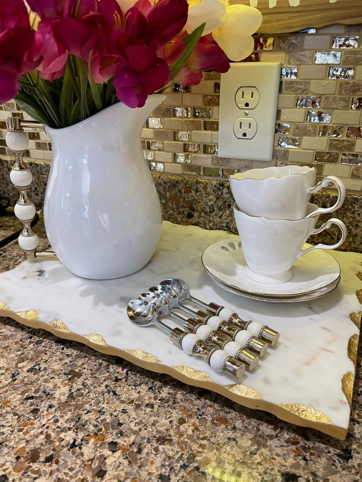 Set of 4 Stainless Steel Dessert Spoons with Gold and White Pearl Designed Handles on coffee stand.
