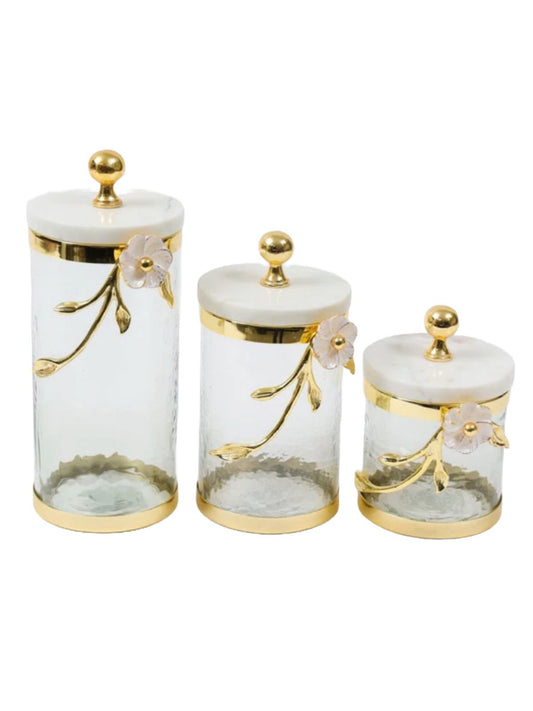 Hammered glass canisters for kitchen home decor with a white enamel and gold leaf flower design, featuring a marble lid topped with a gold knob. Available in three sizes - small, medium, large.