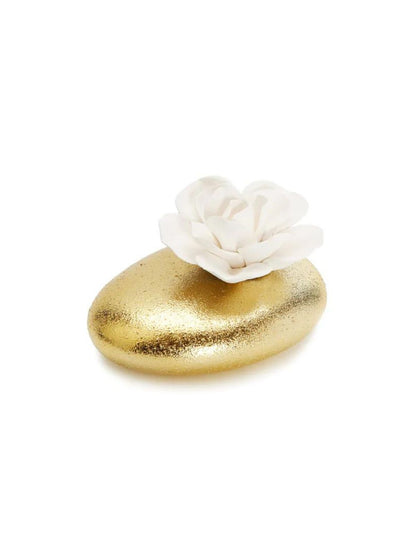 Matte gold porcelain oil diffuser with a white dimensional floral top that dispenses a Lily of the Valley scent. 