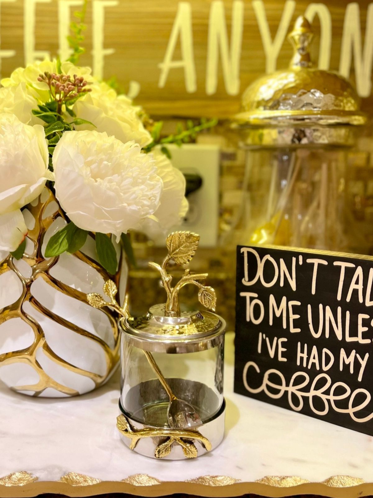 Bring vintage-inspired style to your kitchen or dining room table with this distinctive jar with spoon. It’s made of brass and features a silver-tone circular base and a metal lid with gold-tone raised stems, leaves, and flowers. 