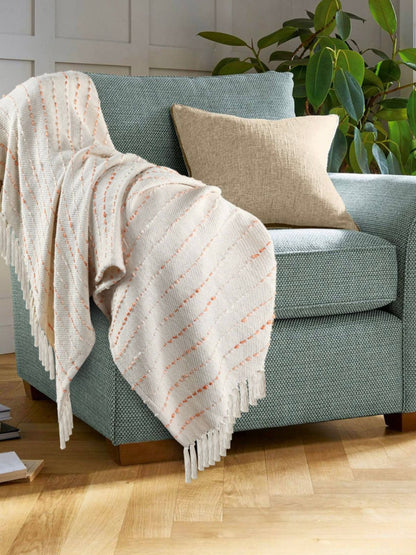 Peach Stripe Woven Cotton Throw Blanket with Fringe, 50W x 60L. Staged on green couch.