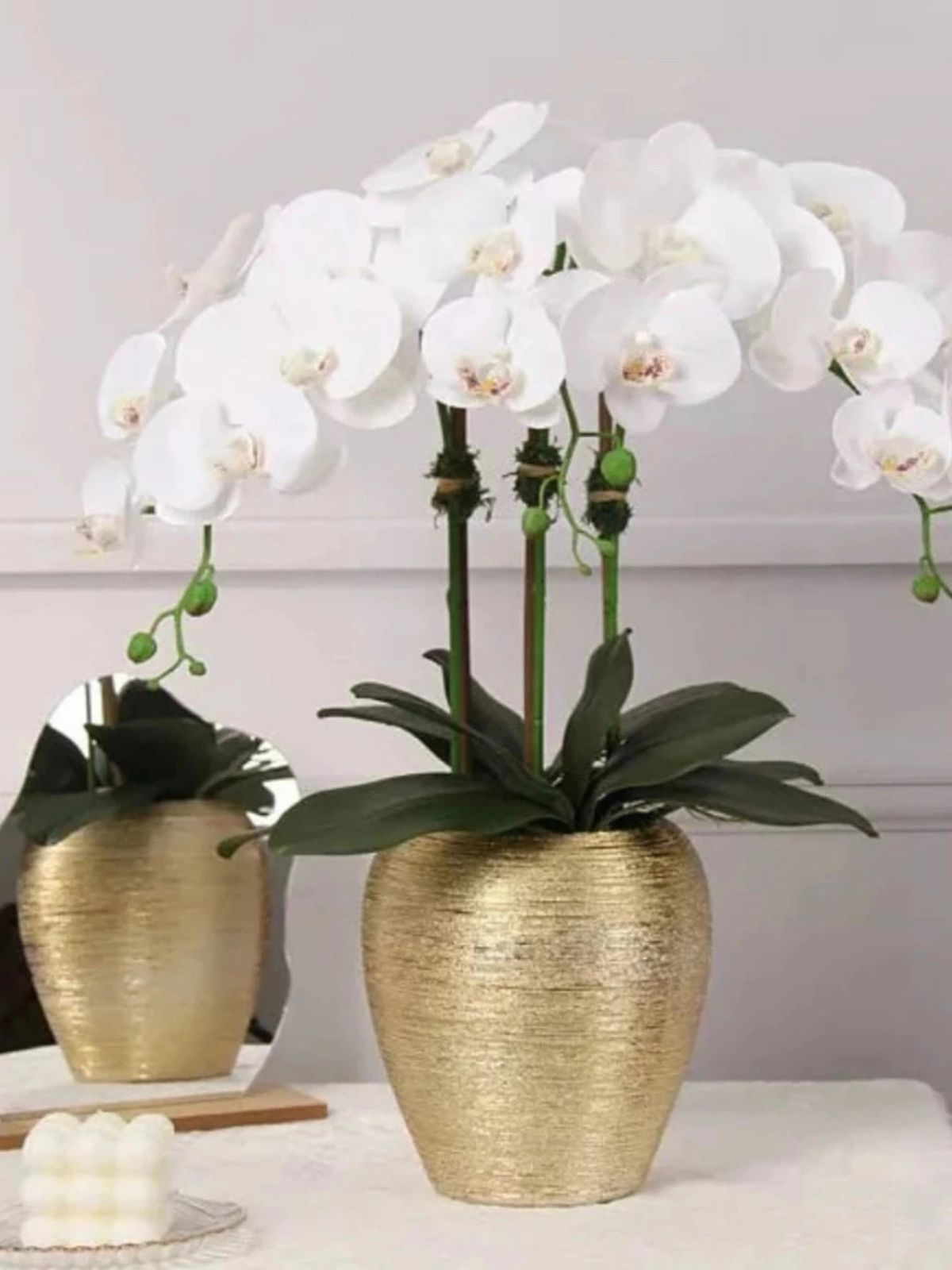 White Silk Orchid Floral Arrangement in Tall Gold Porcelain Vase Staged on Table.