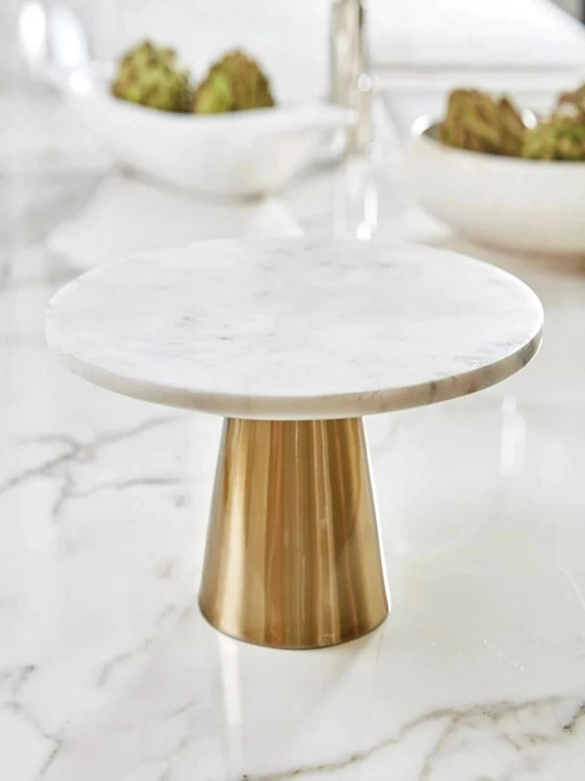 This beautiful 12D cake stand features a natural white marble top and gold brass base sold by KYA Home Decor. 