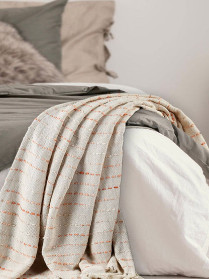 Peach Stripe Woven Cotton Throw Blanket with Fringe, 50W x 60L staged on bed.